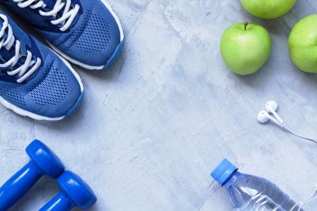 koncept zdravého životného štýlu - tenisky, činky, voda a jablká
