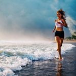 mladá žena športuje na pláži - beh
