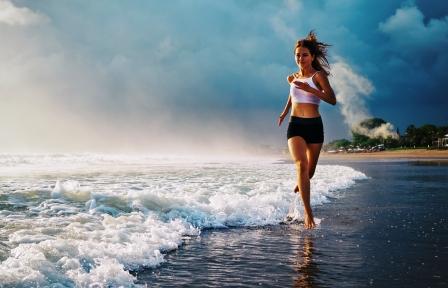 mladá žena športuje na pláži - beh